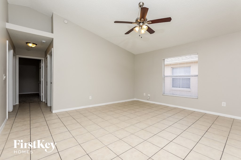 A spacious room with a ceiling fan and a window.