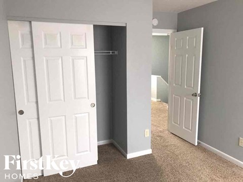 a bedroom with two doors and a closet and a door to a closet