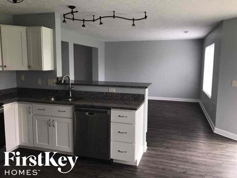 a renovated kitchen with white cabinets and black counter tops