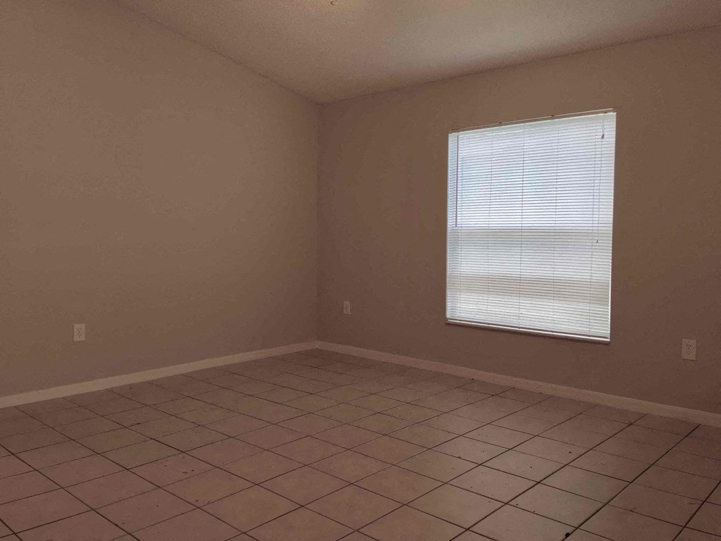 A room with a window and tiled floor.
