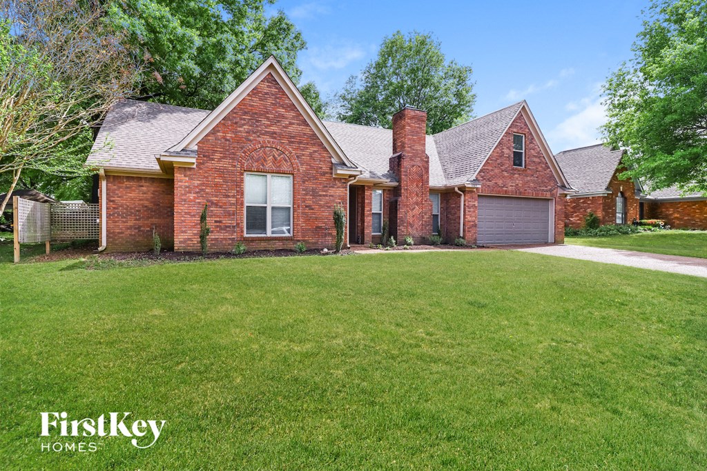 a brick house with a yard in front of it