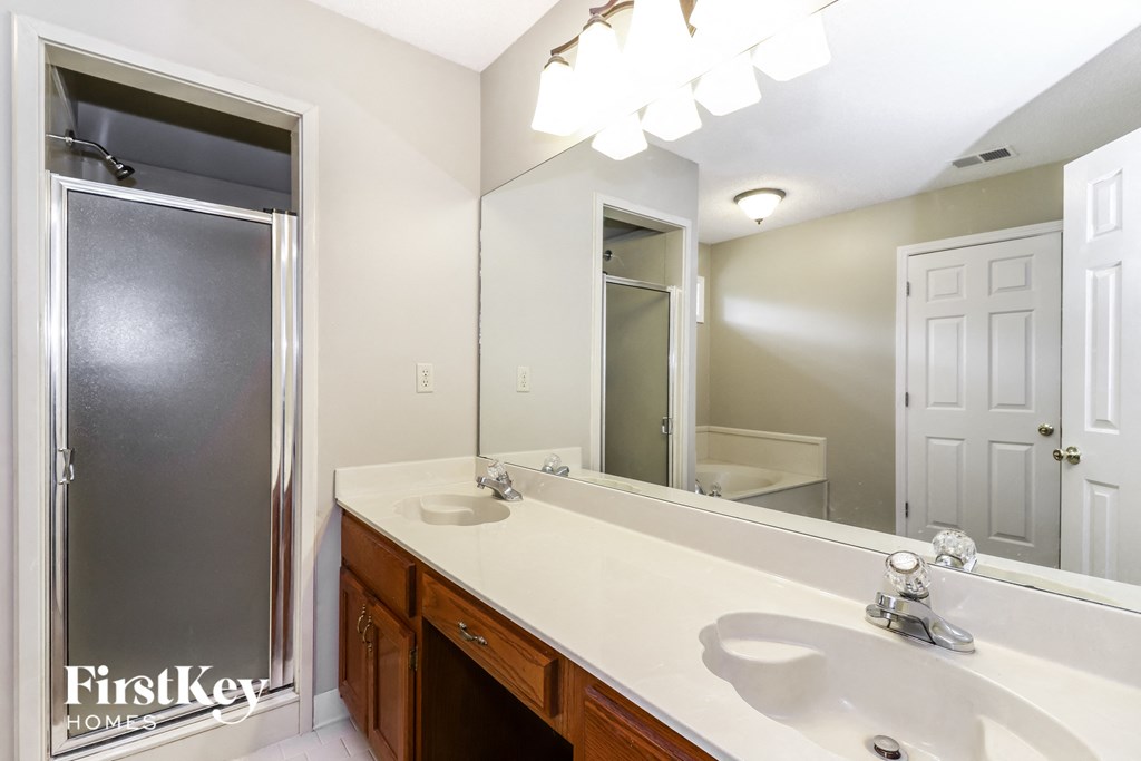 a bathroom with a large mirror and a sink and a shower