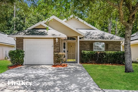 a white garage door in front of a brick house