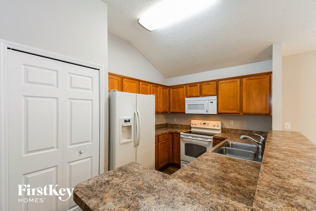 a kitchen with white appliances and granite counter tops