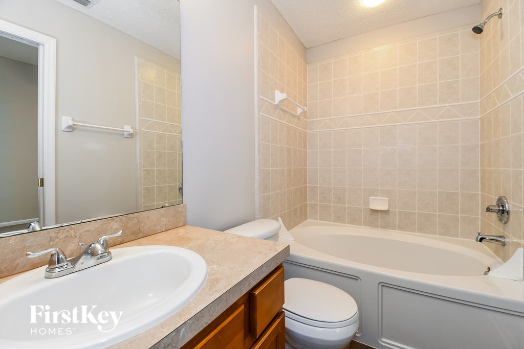 a bathroom with a sink toilet and a tub and a mirror