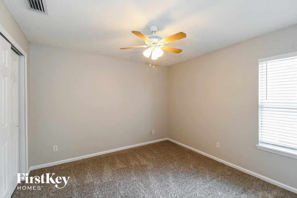 a bedroom with a ceiling fan and a window