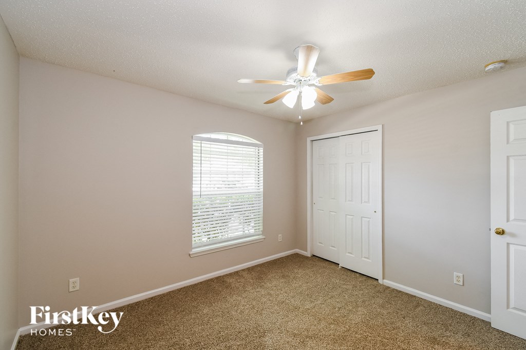 a bedroom with a ceiling fan and a window