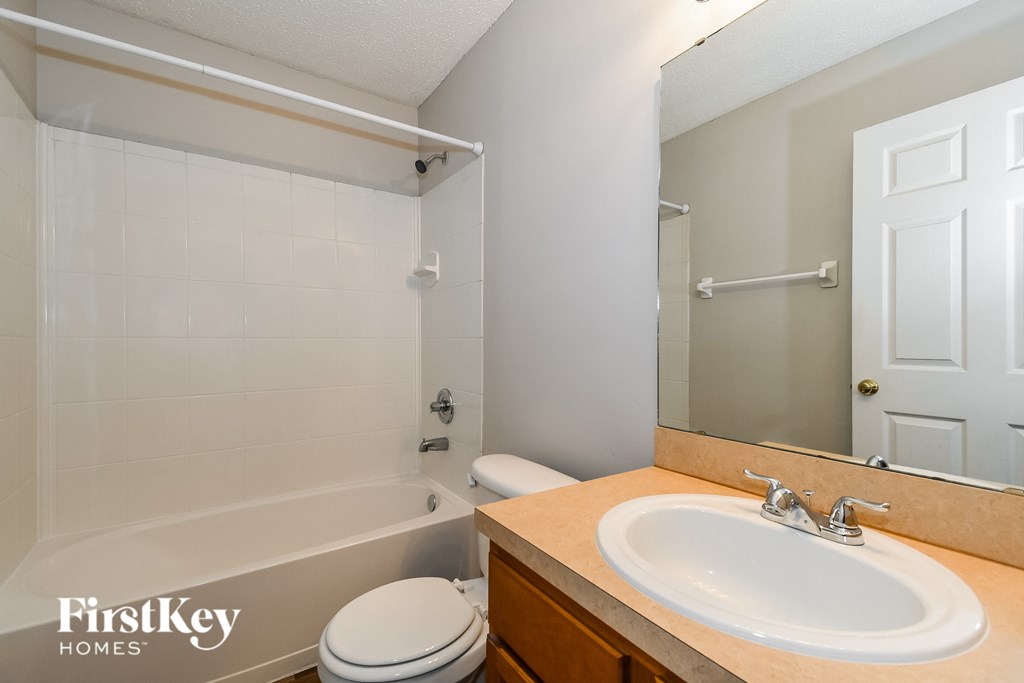 a bathroom with a sink and a tub and a mirror