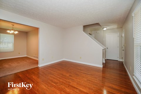 the living room and dining room of an empty house with wood floors