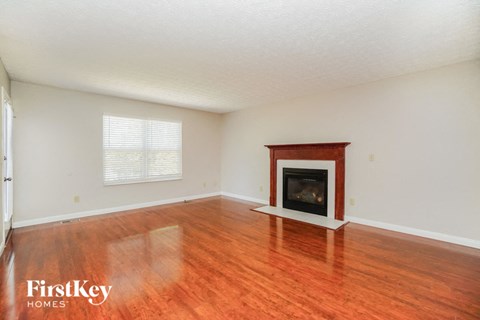 a living room with a fireplace and wooden floors