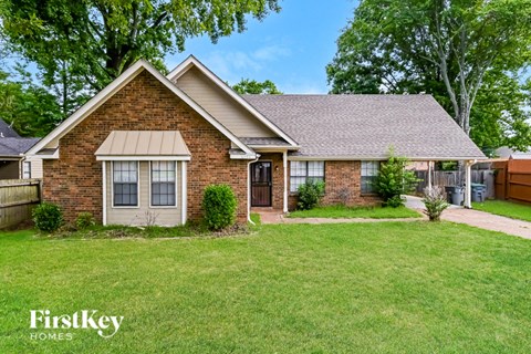 a small brick house with a yard and grass