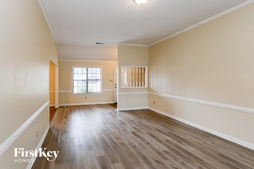 an empty living room with wood floors and white walls