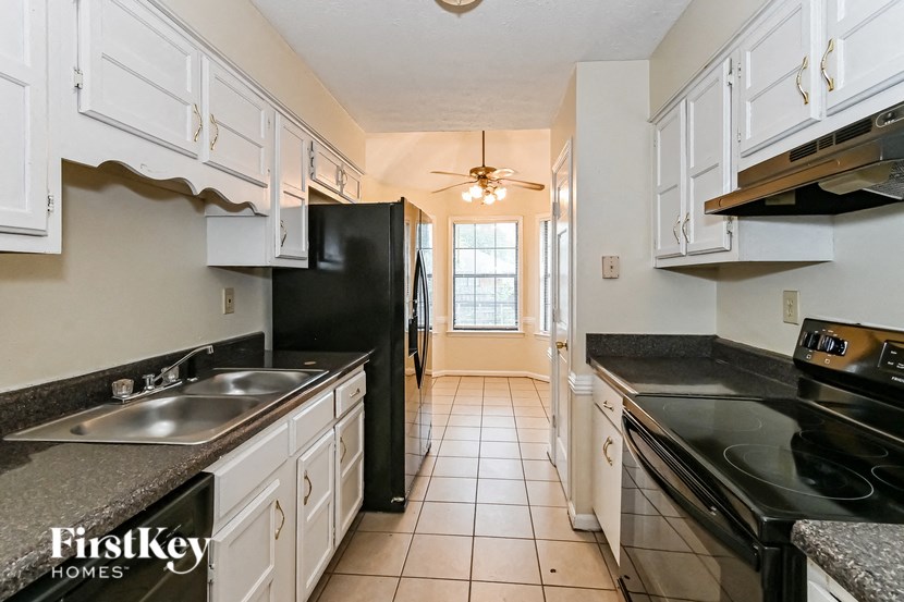 a kitchen with black appliances and white cabinets