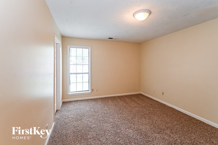 an empty room with carpet and a window