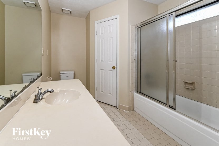 a bathroom with a sink and a shower and a mirror