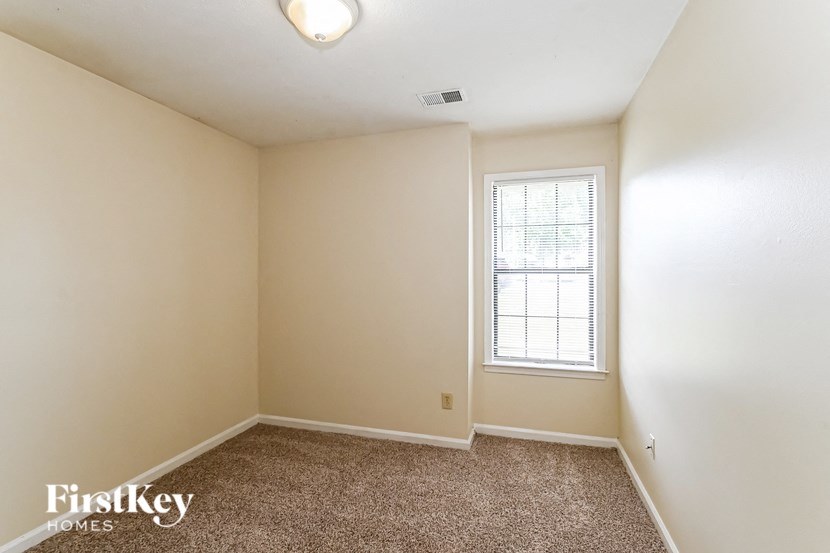 an empty room with carpet and a window