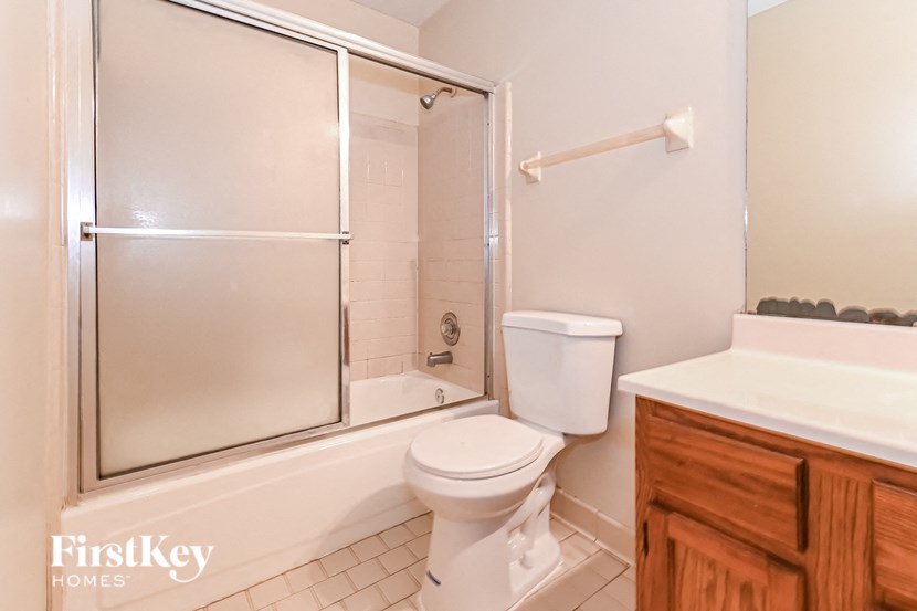 a white bathroom with a shower toilet and sink