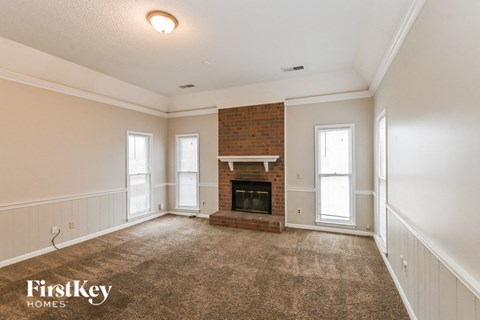 a living room with a fireplace and a carpeted floor