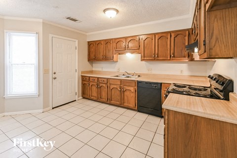 a kitchen with wooden cabinets and a white tiled floor