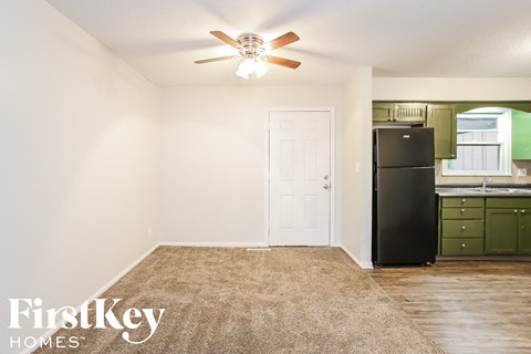a kitchen with a refrigerator and a ceiling fan