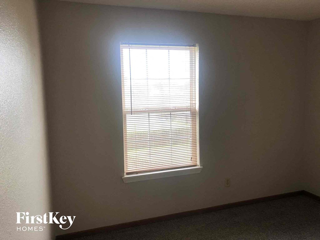 a window with white blinds in a room with white walls