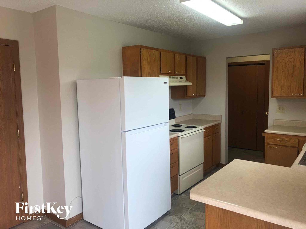 a kitchen with white appliances and wooden cabinets