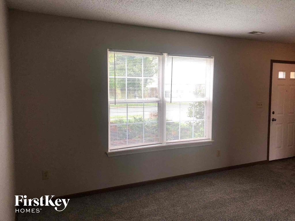 the living room of an empty house with a large window