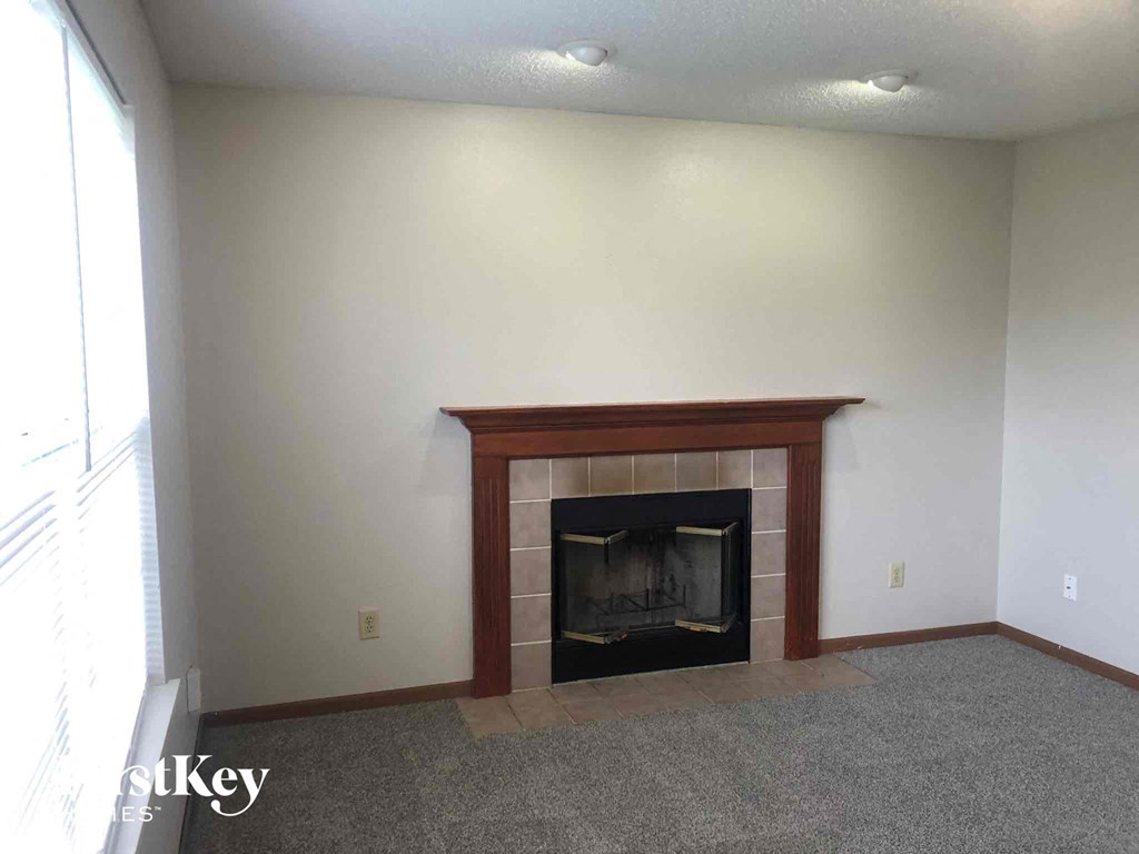 a living room with a fireplace and white walls