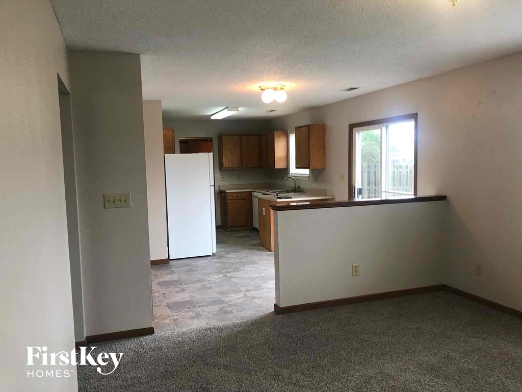 an empty kitchen with a refrigerator and a sink