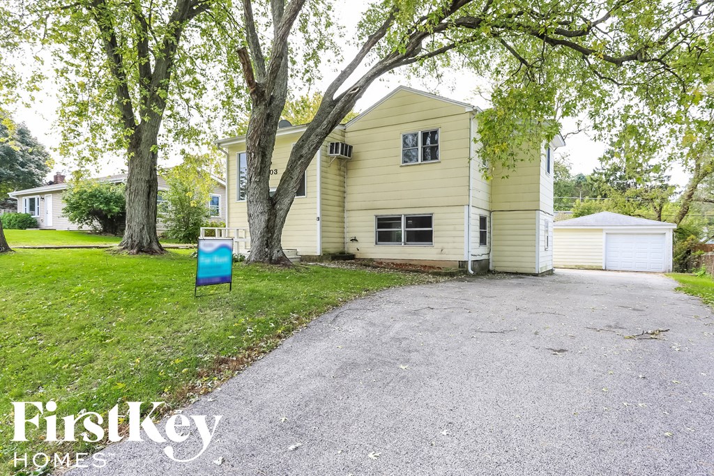 A house with a driveway and a sign that says FirstKey Homes.