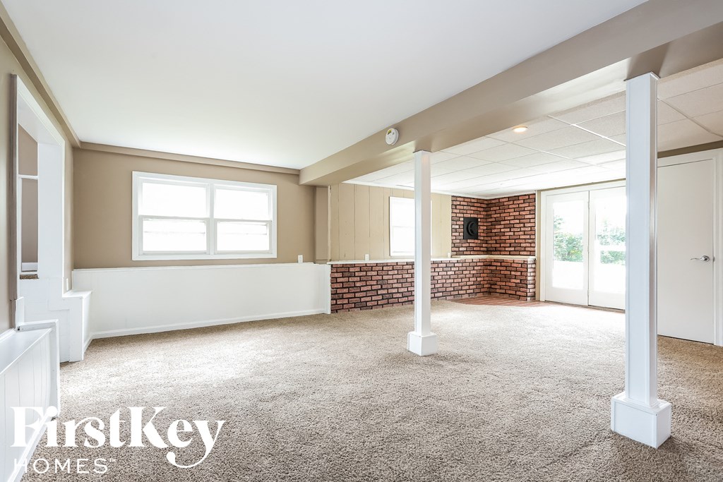 A spacious room with a brick wall and a large window.
