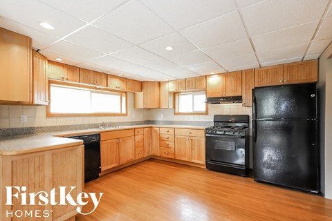 A kitchen with wooden cabinets and black appliances.