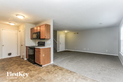 A kitchen area with wooden cabinets and a microwave.
