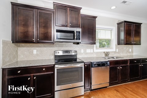 a kitchen with dark wood cabinets and stainless steel appliances