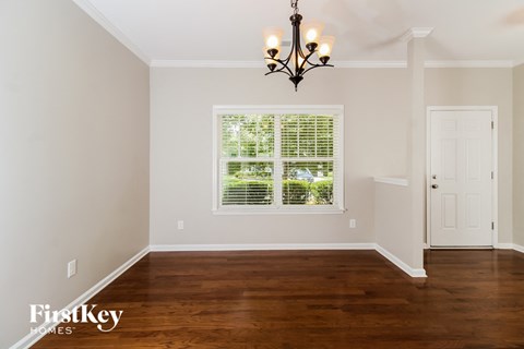 the dining room of a home with wood floors and a window