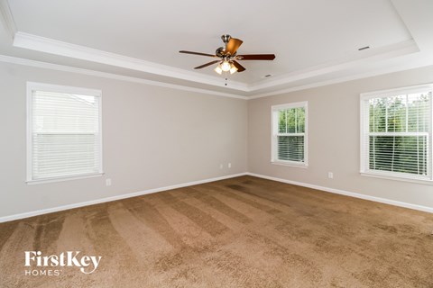a living room with carpet and a ceiling fan