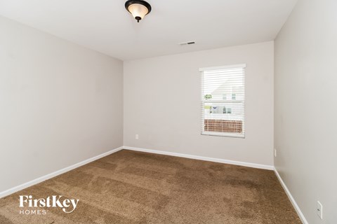 a bedroom with a carpeted floor and a window