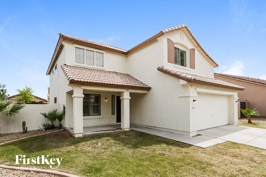 a white house with a lawn and a driveway