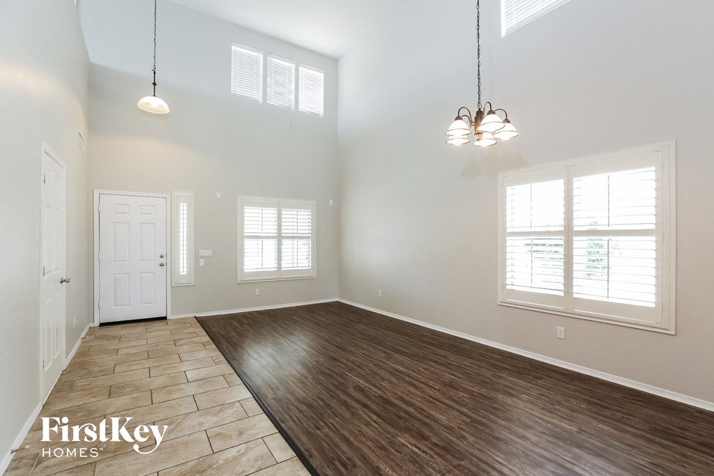 the spacious living room with hardwood flooring and a white door