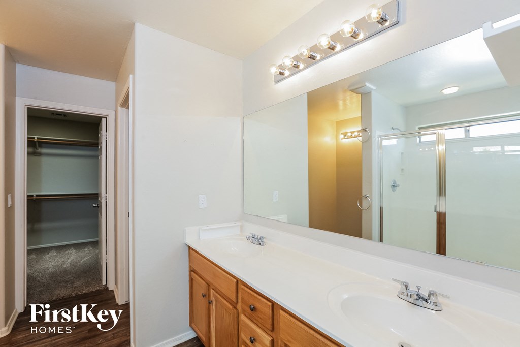 a bathroom with a large mirror and a sink and a shower