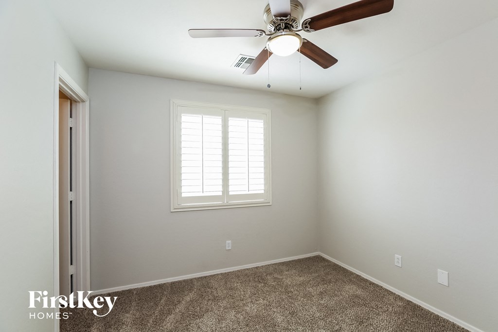 a bedroom with a ceiling fan and a window