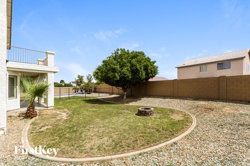 a backyard with a tree and a fence and a house