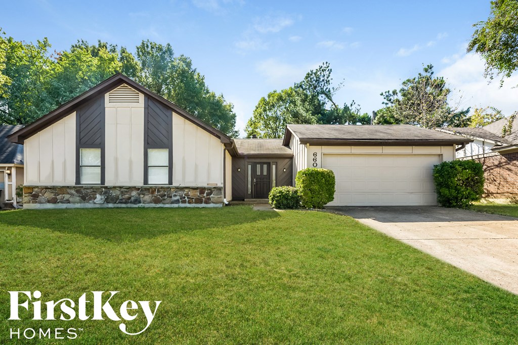 a home with a lawn and a garage
