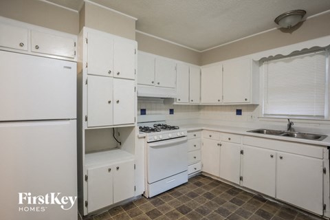 A kitchen with white appliances and cabinets.