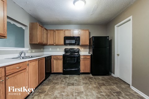 A kitchen with wooden cabinets and black appliances.