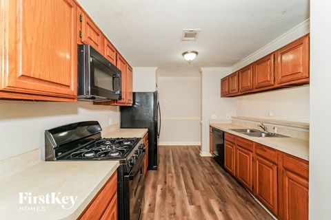 A kitchen with wooden cabinets and a stove top oven.