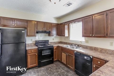 a kitchen with black appliances and wooden cabinets