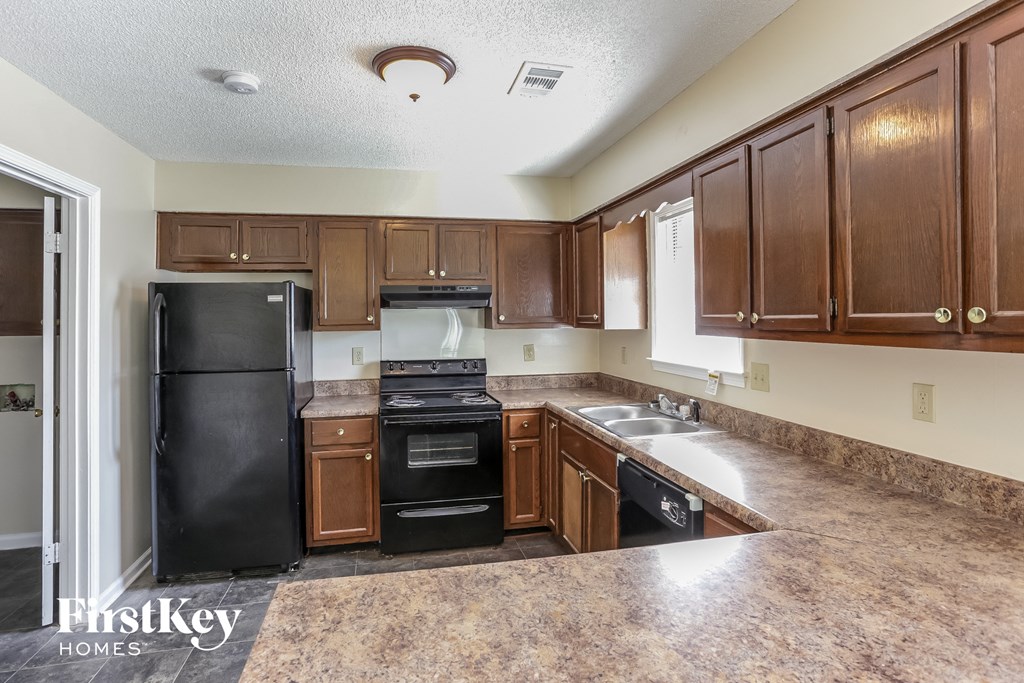 a kitchen with black appliances and wooden cabinets