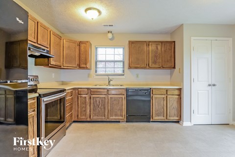 A kitchen with wooden cabinets and black appliances.