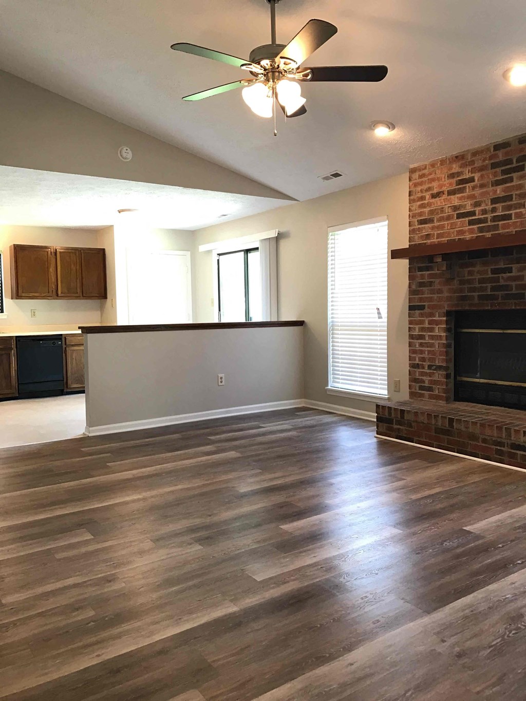 A room with a fireplace and a ceiling fan.